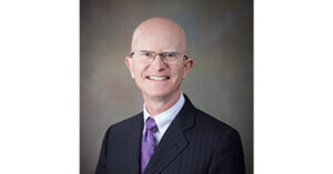 A professional headshot of the Board member.