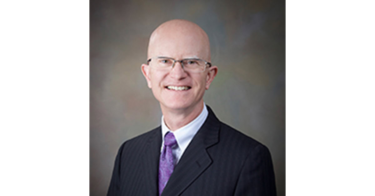 A professional headshot of the Board member.