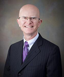 A professional headshot of the Board member.