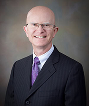 A professional headshot of the Board member.