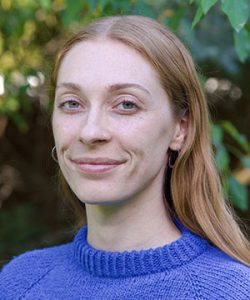 Headshot of Bailey outside in a purple sweater.