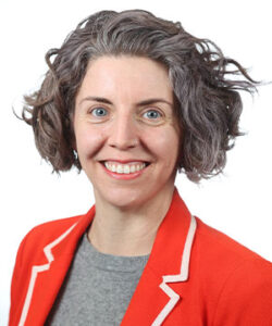 Bethany headshot in a red jacket and a white background