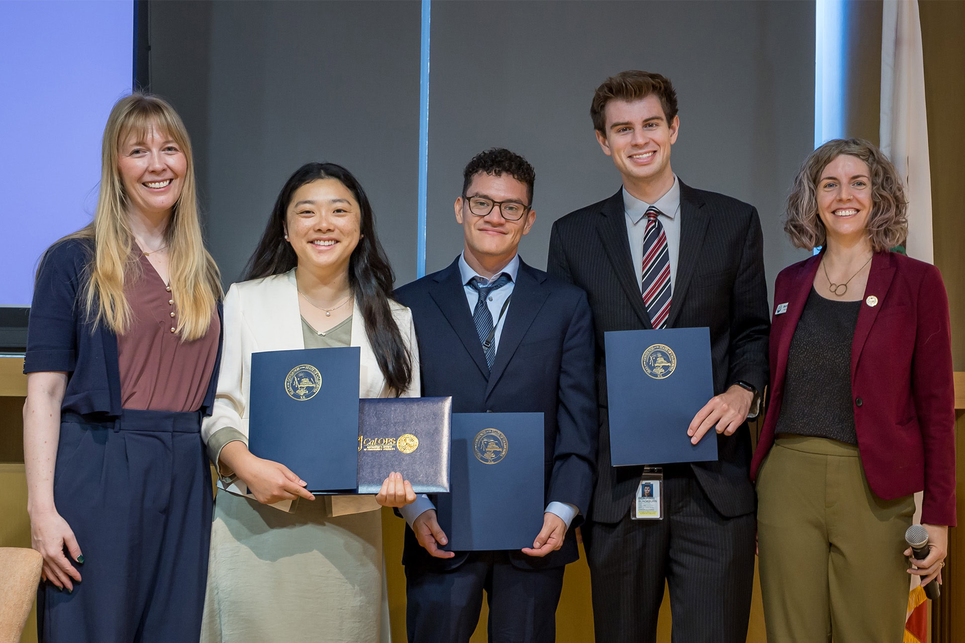 Fellows pose for a group photo on stage at Science Day 2026