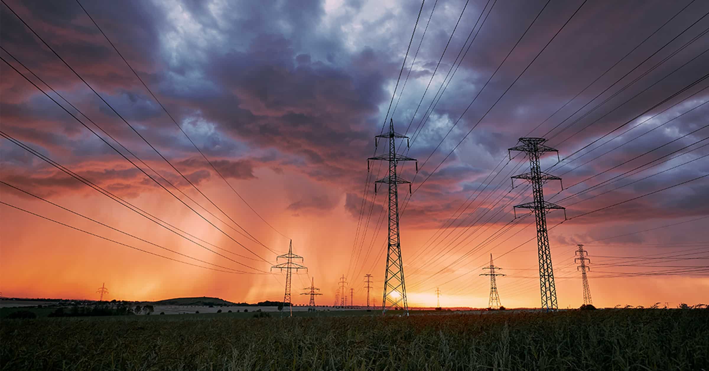Photo of electricity towers under cloudy skies.