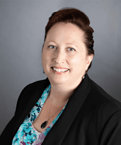 Headshot in formal wear with a gray indoor background