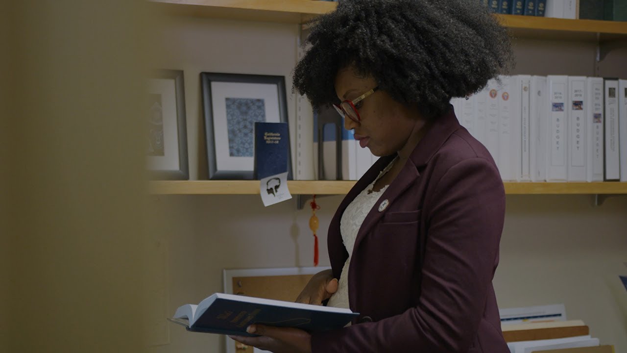 Debra Cooper in her office paging through a legal book.