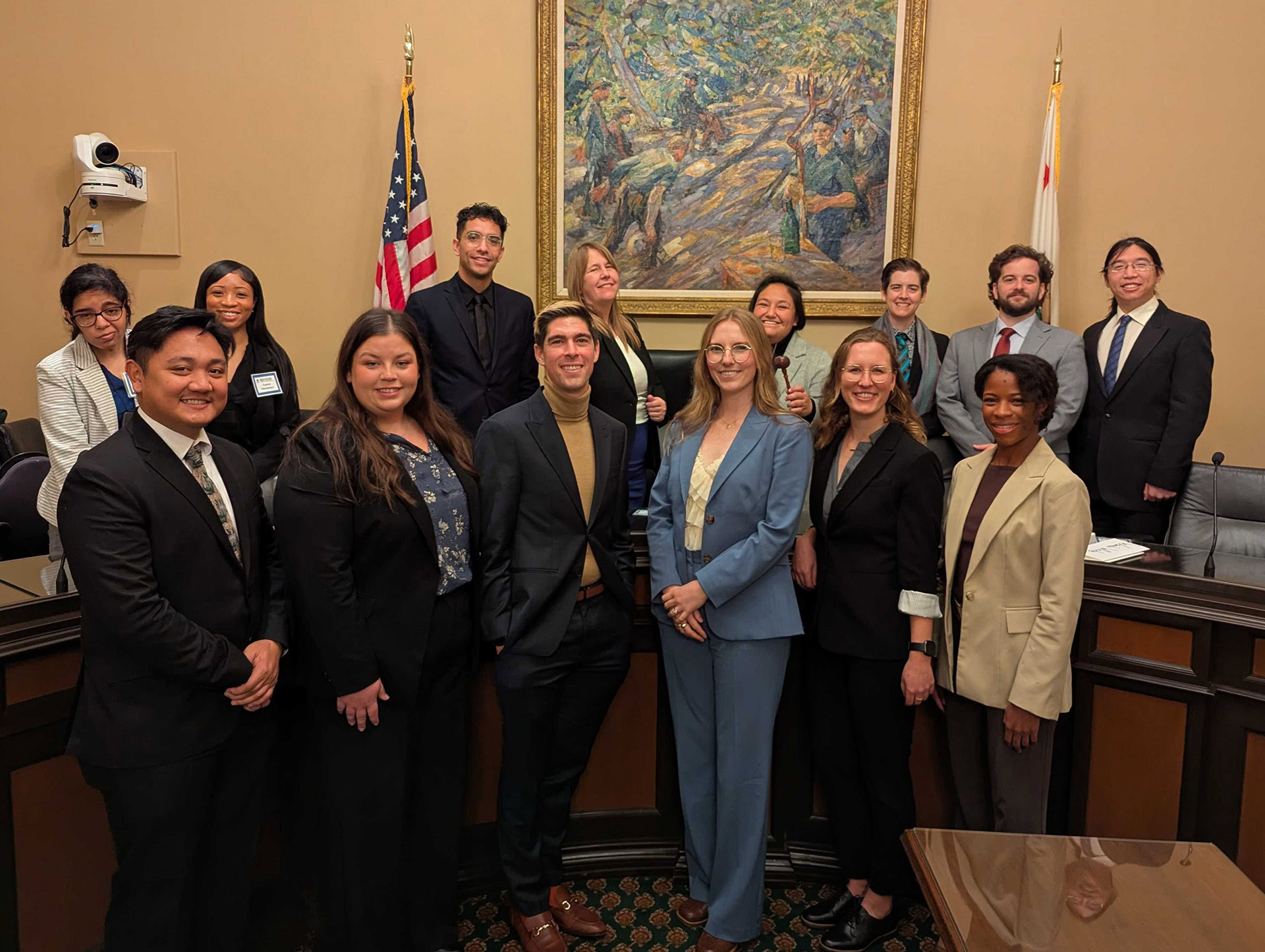 Fellows post at a dais in a committee hearing room