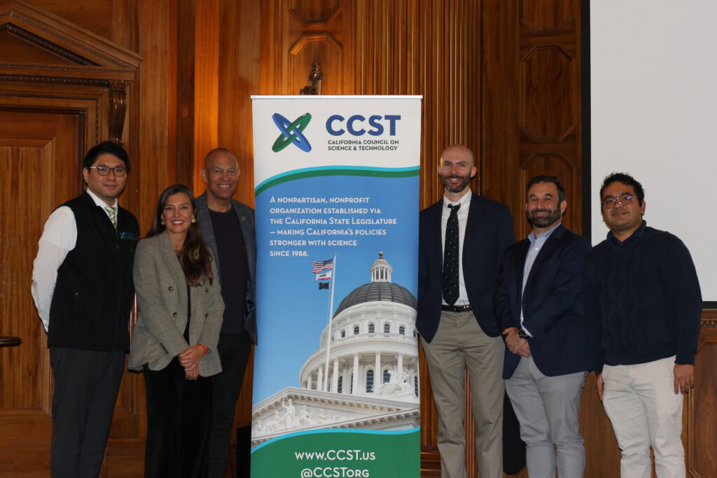 Panelists pose for a photo with a CCST banner in the middle