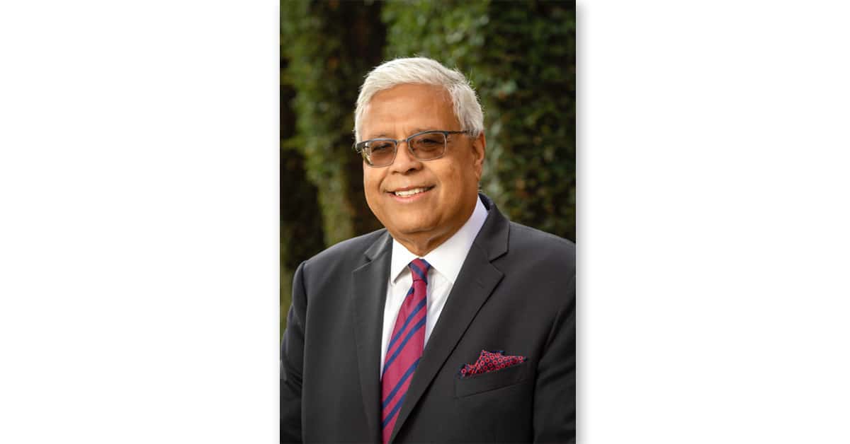 A photo of Ishwar Puri in a suit and tie with sunglasses