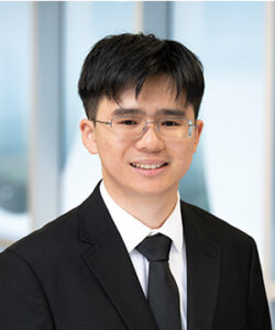 Professional headshot of Jason in a black suit.