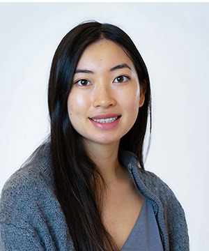 Professional headshot of Jenna in a grey sweater.
