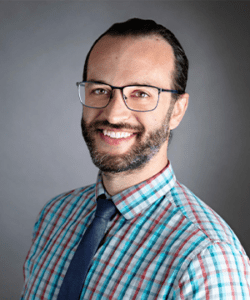 Headshot in formal wear with a gray indoor background