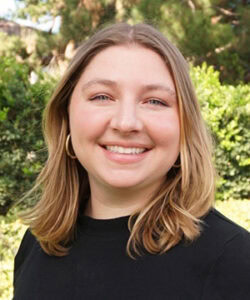 Professional headshot of Kayla in a black sweater.