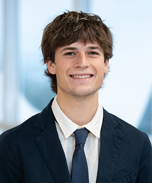 Professional headshot of Kole in a black suit.