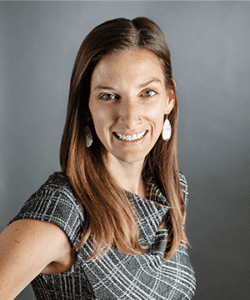 Headshot in formal wear with a gray indoor background