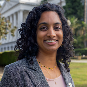 A formal headshot in front of the California State Capitol.